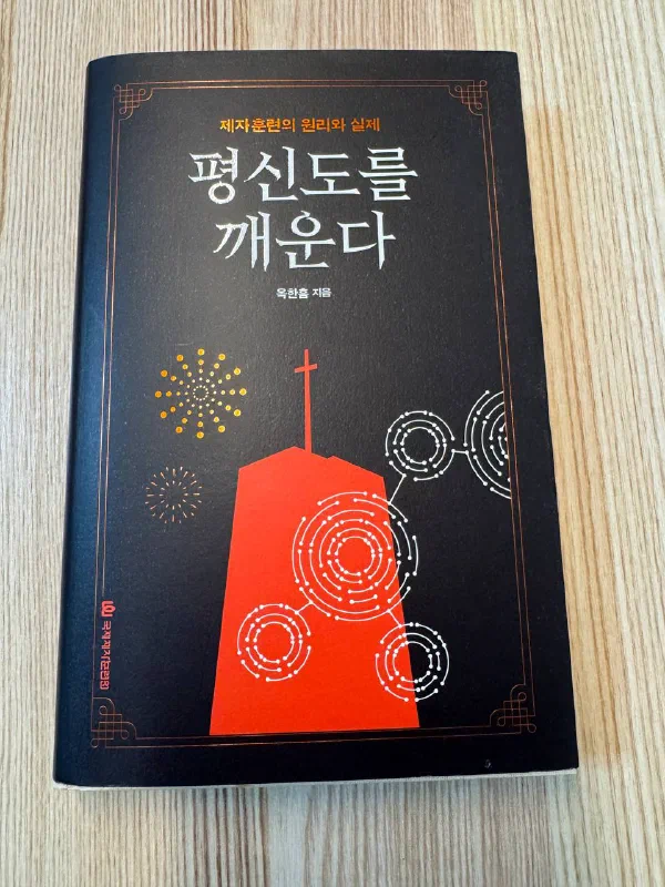 옥한흠 목사의 대표작 『평신도를 깨운다』 표지. 검은색 바탕에 흰 글씨로 제목이 있고 아래에 빨간색 삼각형 모양 건축물 같은 이미지가 그려져 있다.