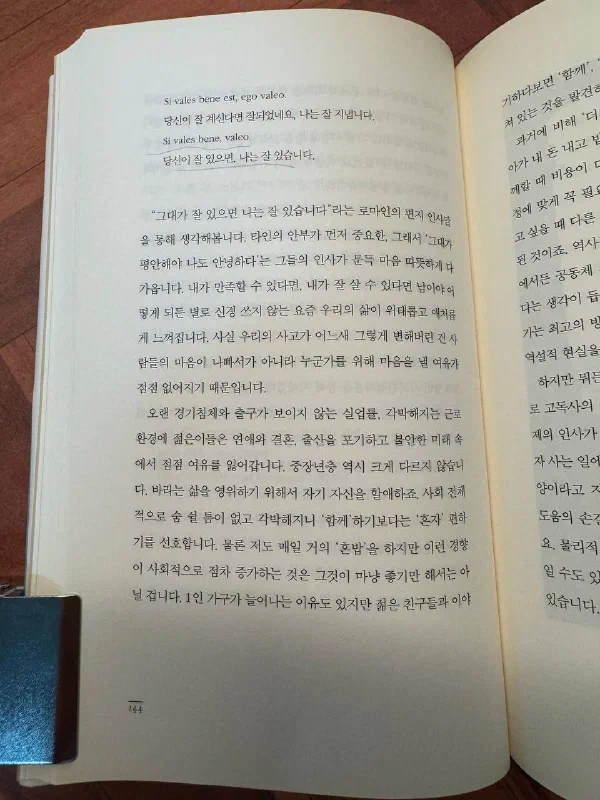 책 144쪽. 「Si vales bene est, ego valeo」와 「당신이 잘 계신다면 잘되었네요, 나는 잘 지냅니다」, 그리고 「Si vales bene, valeo」와 「당신이 잘 있으면, 나는 잘 있습니다」가 나란히 인용되어 있다. 이어지는 본문은 타인의 안부가 먼저 중요한 로마인의 인사말과, 「함께」하기보다 「혼자」 편하기를 선호하게 된 오늘의 각박한 사회를 이야기한다