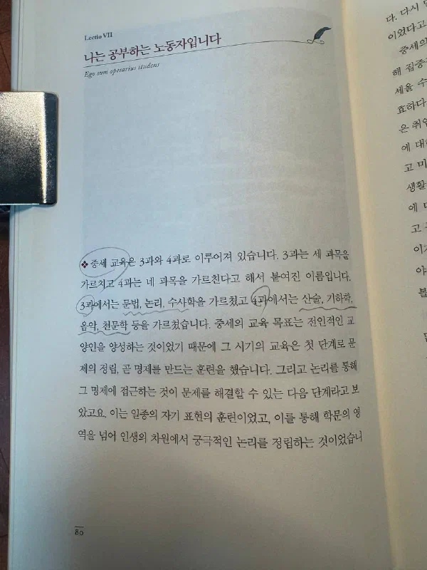 책 80쪽. 「Lectio VII」 아래에 「나는 공부하는 노동자입니다」라는 제목과 라틴어 「Ego sum operarius studens」가 적혀 있다. 본문에는 중세 교육이 3과와 4과로 이루어져 있었고 3과에서는 문법, 논리, 수사학을, 4과에서는 산술, 기하학, 음악, 천문학을 가르쳤다는 설명이 연필 표시와 함께 남아 있으며, 중세 교육의 목표가 전인적인 교양인 양성이었다는 문장이 이어진다