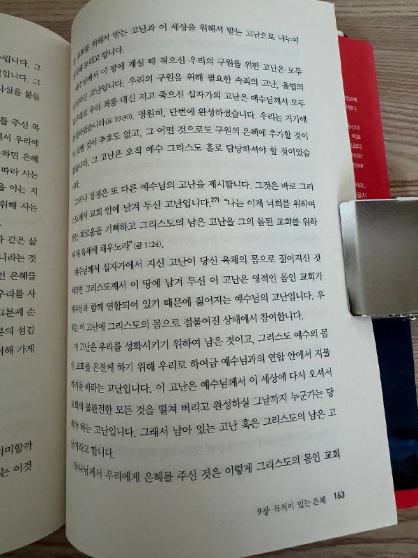 책 163쪽, 9장 &lsquo;목적이 있는 은혜&rsquo; 중 골로새서 1장 24절 &lsquo;그리스도의 남은 고난을 그의 몸된 교회를 위하여 내 육체에 채우노라&rsquo;를 인용하며 고난을 설명하는 대목. 페이지 옆에 금속 북클립이 끼워져 있다