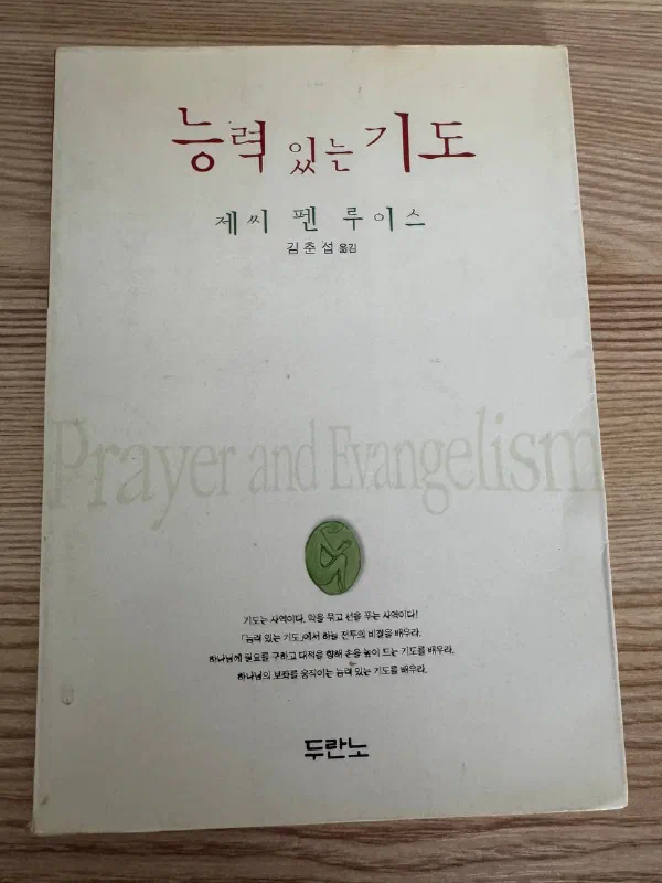 나무 바닥 위에 놓인 『능력 있는 기도』 표지. 제씨 펜 루이스, 김준섭 옮김, 두란노라는 글자가 보인다
